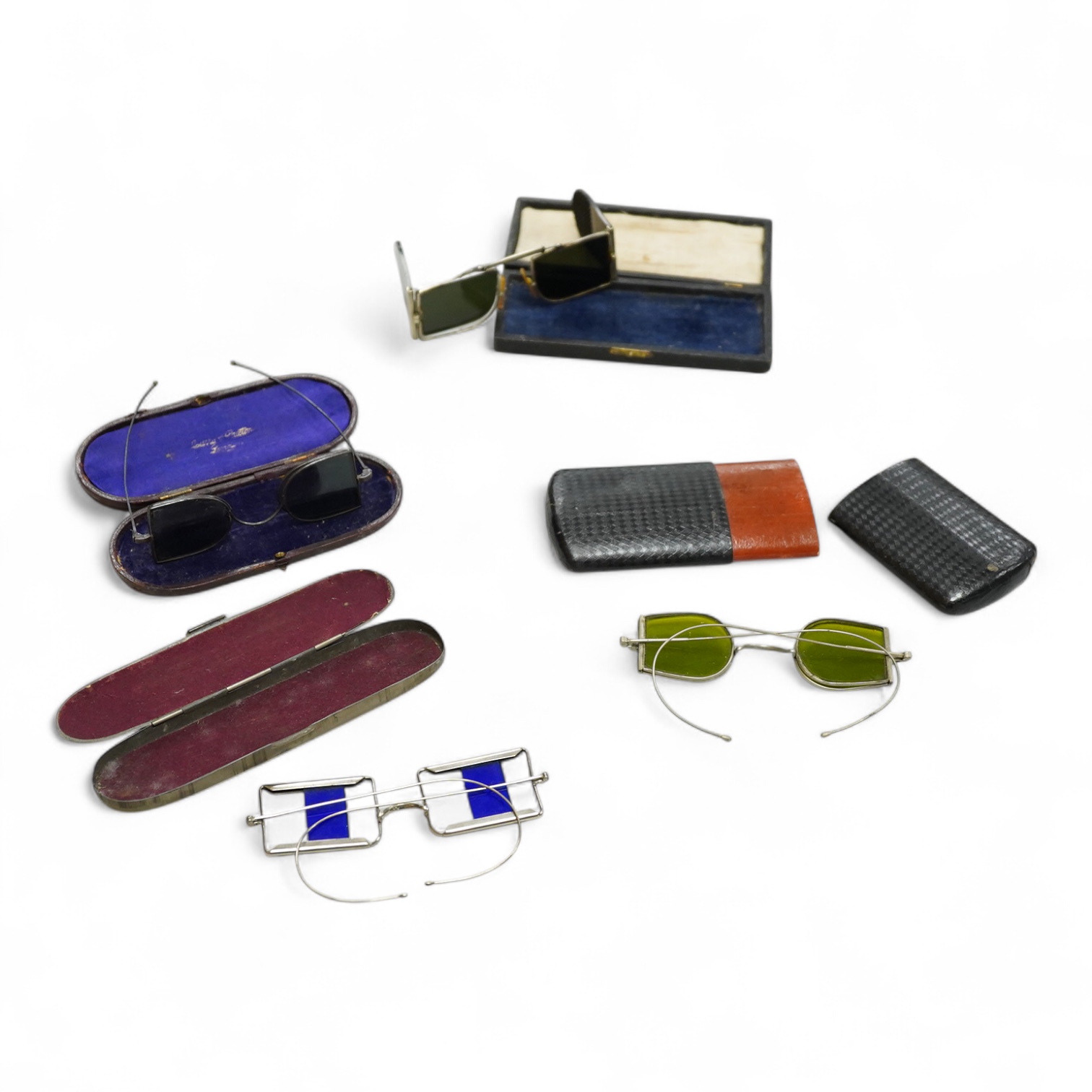 Two pairs of 19th century double D folding tinted spectacles, both cased, an unusual pair of green tinted pince nez with vulcanite side eye protectors, cased and a pair of optometrist ‘patent’ spectacles with sliding blu